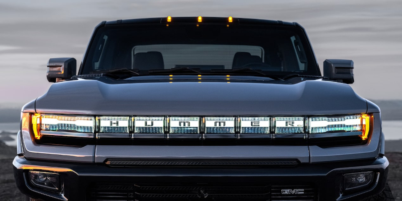 Front view of a GMC Hummer EV with illuminated light bar and grille.